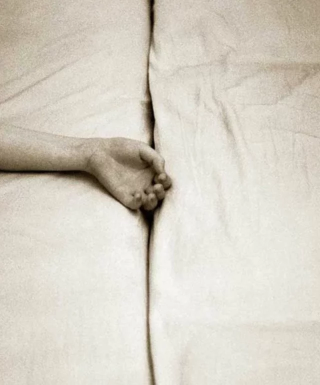A photographic meditation on distance and intimacy.
In Dialogue, Rudolf Bonvie frames a quiet tension: two hands reach across the seam of a divided bed, suspended between contact and withdrawal. The composition is minimal, nearly clinical, but the emotion is dense and quietly charged. Here, the bed becomes a stage, the gesture a conversation. What connects us is also what separates us. In this still moment, Bonvie captures the architecture of relationship as something soft, fragile, and unresolved.

• Rudolph Bonvie, Dialogue (1973) 🤍

Via @cosmos